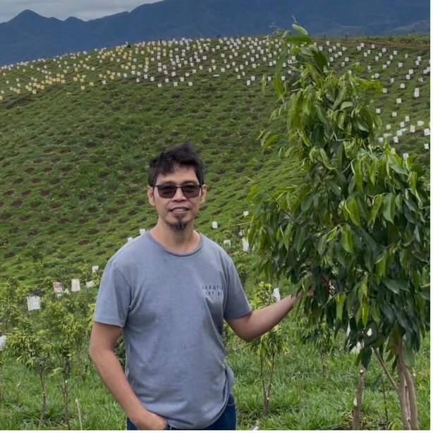 Jesse Veluz standing beside one of his agarwood trees at a Bukidnon plantation on February 13, 2026.